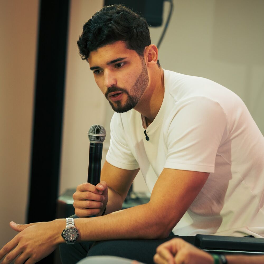 Marcos Machado sentado conversando com a plateia